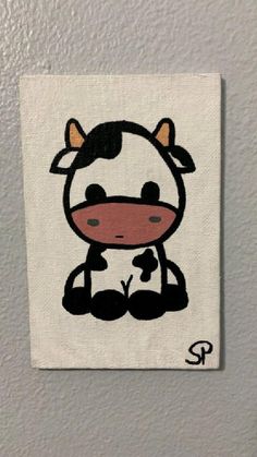 a painting of a cow sitting on top of a white wall