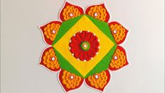 an intricately designed piece of cloth with red and yellow flowers in the center on a white surface