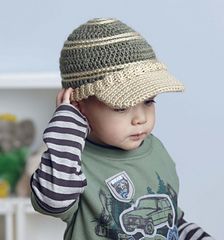 a small child wearing a hat while holding his hand up to his ear