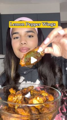 a woman is eating some food from a bowl with the caption lemon pepper wings