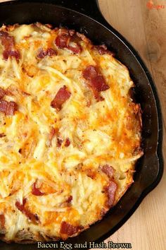 an omelet with bacon and hash browns in a cast iron skillet on a wooden table