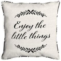 a white pillow with black lettering that says enjoy the little things in front of it