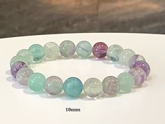 "Very pretty natural fluorite crystal bracelet featuring grade AA+ fluorite beads. Made with high-quality stretch cord that easily slides over your hand and wrist. See all item photos.  Available in bead sizes; 7mm, 8.5mm, 10mm & 12mm.   ** Different size beads have slightly different color tones, please see all item photos before purchasing. **  Fluorite cleanses and stabilizes the aura.  It absorbs and neutralizes negative energy and stress.  An excellent learning aid, Fluorite increases our p Fluorite Gemstone Bracelets With Round Beads, Fluorite Bracelet, Bead Sizes, Fluorite Crystal, Color Tones, Nature Bracelets, Crystal Bracelet, Negative Energy, Gemstone Bracelet