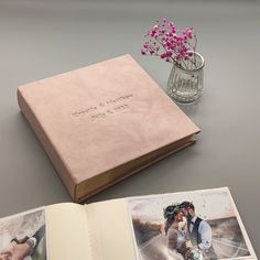 an open book with photos and flowers on the table