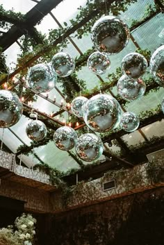 the ceiling is covered with glass balls and greenery