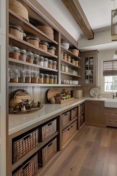 a kitchen filled with lots of wooden shelves and baskets on top of the counter tops