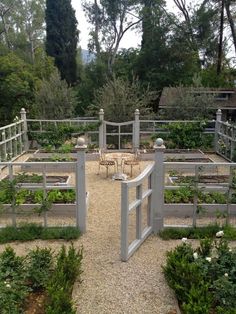 an outdoor garden with several different types of plants and seating areas, including benches and tables