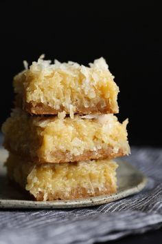 three pieces of coconut bars stacked on top of each other in front of a black background