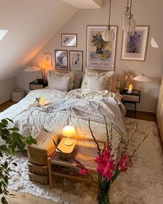 a bedroom with a large bed and pictures on the wall above it, along with candles