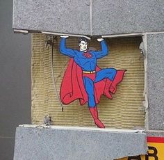 there is a painting on the side of a building that has a superman painted on it