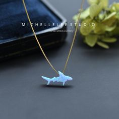 a small white shark necklace sitting on top of a table