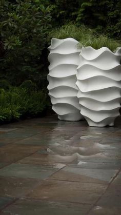 a large white vase sitting on top of a stone floor