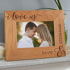 a wooden frame with the words i love us and a photo of a man and woman