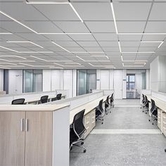 an empty office cubicle with desks and chairs