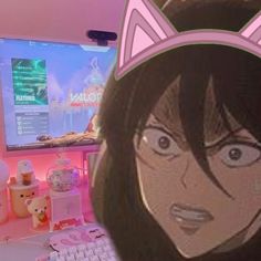 a girl with cat ears on her head in front of a computer screen and keyboard