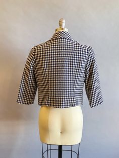 "1960s wool navy blue and white cropped jacket with a houndstooth print. Three-quarter sleeves. Two large center navy resin buttons and matching navy taffeta lining. Size- Medium Bust - 36\" Waist - 34\" Length - 18\" Sleeves - 19\" Label: Irvington Palace Sportswear by Lili Condition: Excellent vintage condition. All vintage is sold in \"as-is\" condition. We do our best to inspect, correct, and list important flaws. All measurements are made with the garment laying flat. Length is measured fro Retro Fitted Cropped Outerwear, Fitted Retro Cropped Outerwear, Fitted Vintage Outerwear With Houndstooth Pattern, Retro Cropped Outerwear For Fall, Vintage Cropped Outerwear For Work, Fitted Vintage Cropped Jacket For Work, White Cropped Jacket, Broadway Costumes, Navy Blue Cocktail Dress