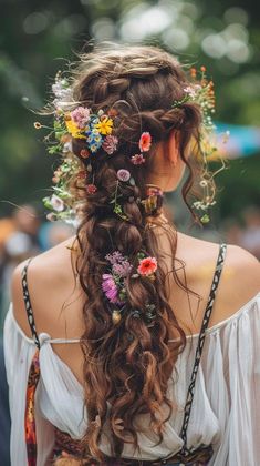 a woman with flowers in her hair wearing an off the shoulder top and braids