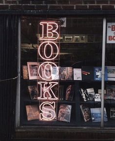 a book store window with the words books lit up on it's display shelf