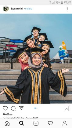 a group of women in graduation gowns posing for a photo on steps with their arms outstretched