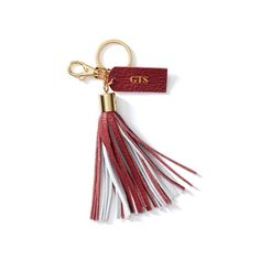 a red and white tasselled keychain with the word cis on it