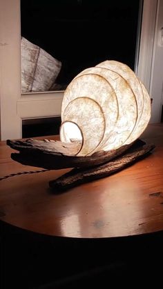 a wooden table topped with a lamp on top of it next to a window sill