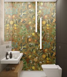 a bathroom with a toilet, sink and wallpaper in the shape of oranges