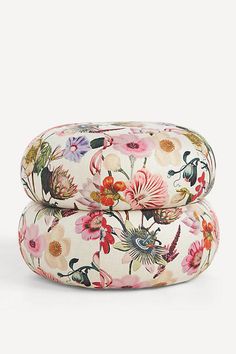 two floral pillows sitting on top of each other