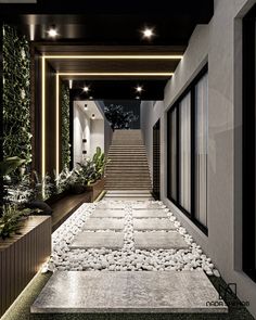 a long hallway with steps leading up to the top floor and plants on either side