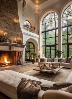 a living room filled with lots of furniture next to a fire place and large windows