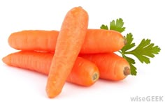 three carrots with green leaves on top of them, sitting next to each other