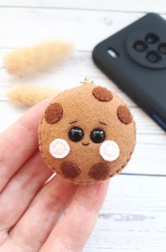 a hand holding a small brown and white stuffed animal