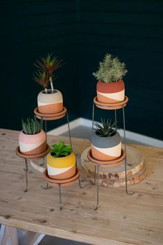 three tiered planters with succulents and plants on them sitting on a wooden table