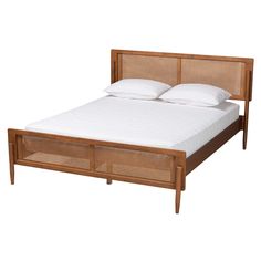 a bed with two pillows on top of it and a headboard made out of wood