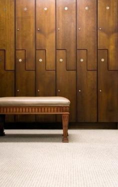 a bench sitting in front of a wall with wooden panels on it's sides