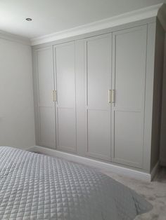 a bedroom with white cabinets and a large bed