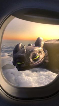 an image of a dragon flying in the sky from inside an airplane's window