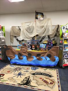 a pirate ship made out of foam on the floor next to a rug and bookshelf