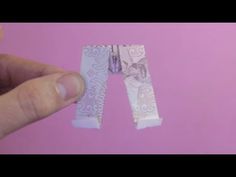 someone is cutting out the letters from paper with scissors and glue on a pink background