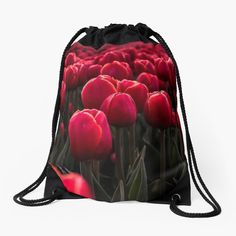 a drawstring bag with red tulips in the foreground, on a white background