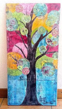 a painting with many different colors and shapes on it, including a tree in the middle