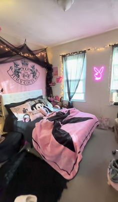 a bedroom decorated in pink and black with fairy lights