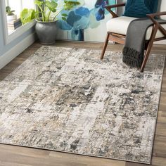 an area rug in a living room with a chair and potted plant on the floor