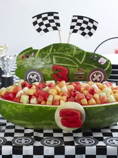 a car made out of watermelon is sitting on a checkered tablecloth