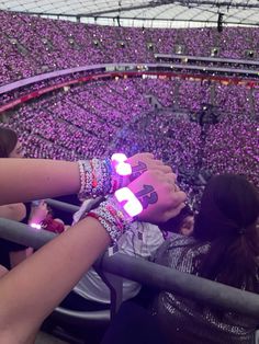 two girls are holding their hands together in front of an audience at a sporting event