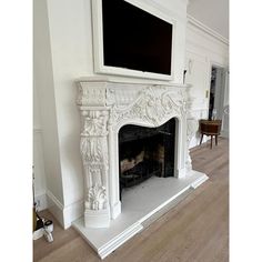 a white fireplace with a flat screen tv above it