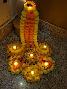 an arrangement of flowers and candles on the ground in front of a light - up candle holder