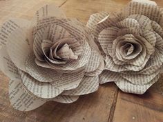 two paper flowers sitting on top of a wooden table