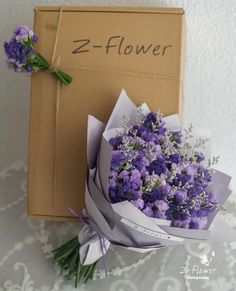 a bouquet of purple flowers sitting in front of a box