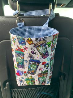 a bag hanging from the back seat of a car with cartoon characters on it,