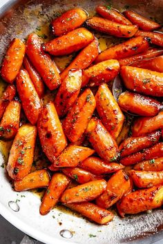 cooked carrots in a pan with herbs on top